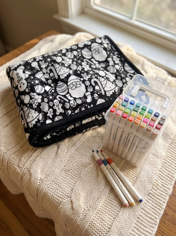 The folded blanket beside its case of fabric markers